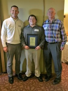 Levi Bahr with a plaque for his training success.