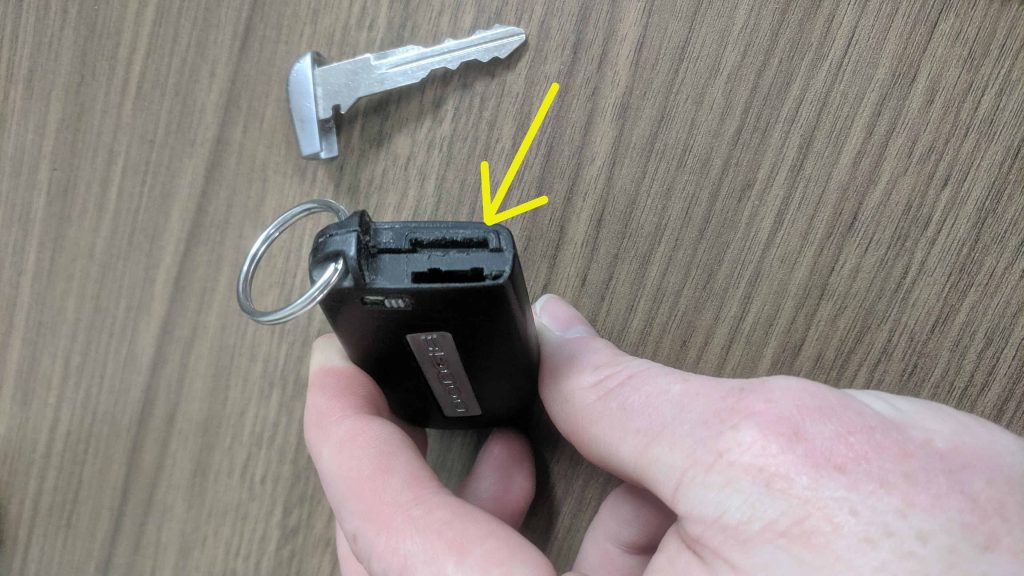 Arrow point to the spot where to open the key fob to access the battery.