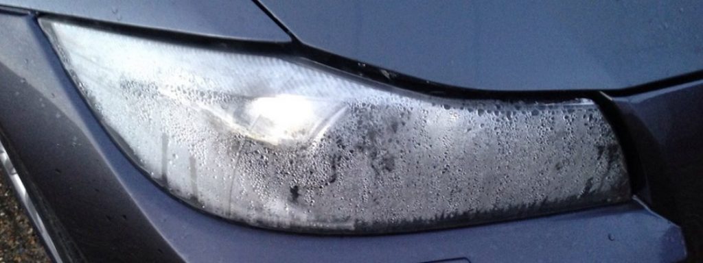 Moisture is built up in a vehicles headlight causing difficulty to see during winter driving.